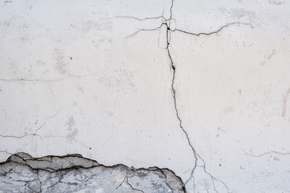 Fissure verticale traversant un mur enduit